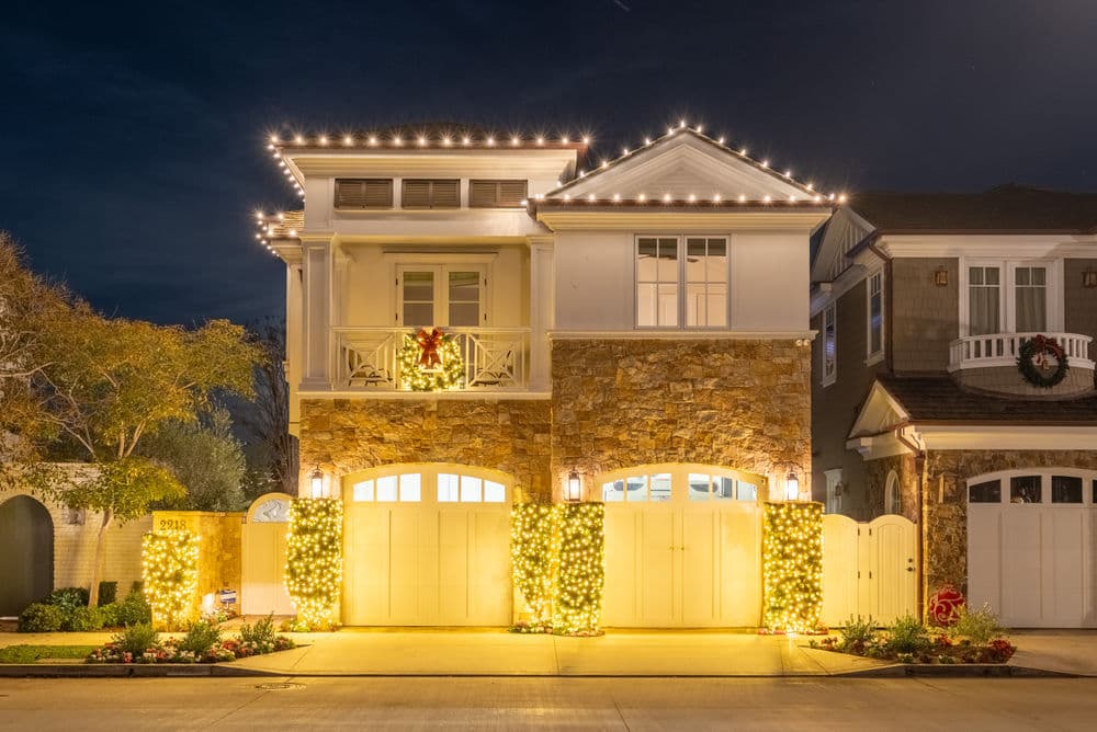 Decorated luxury home with festive lights and wreath during the holiday season.
